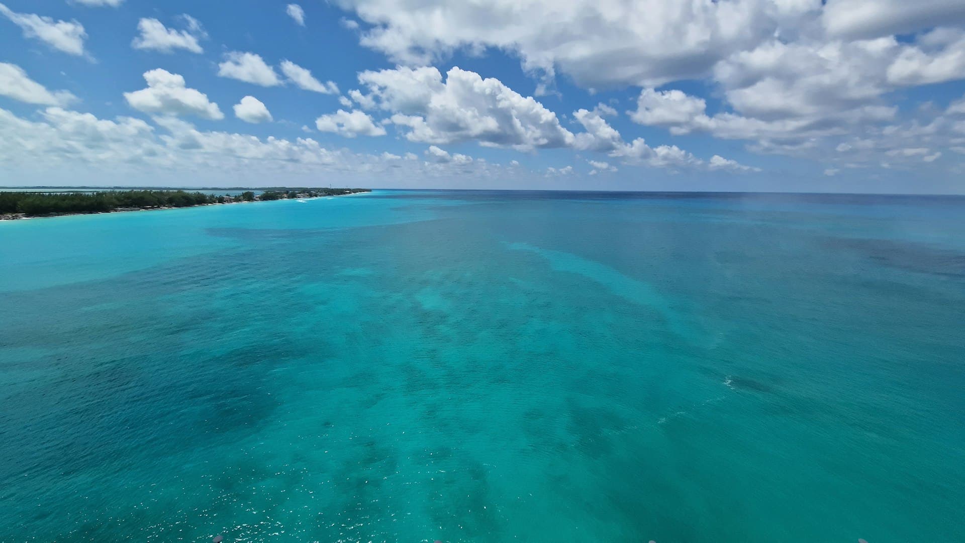 Aerial view of a calm turquoise ocean and sandbar